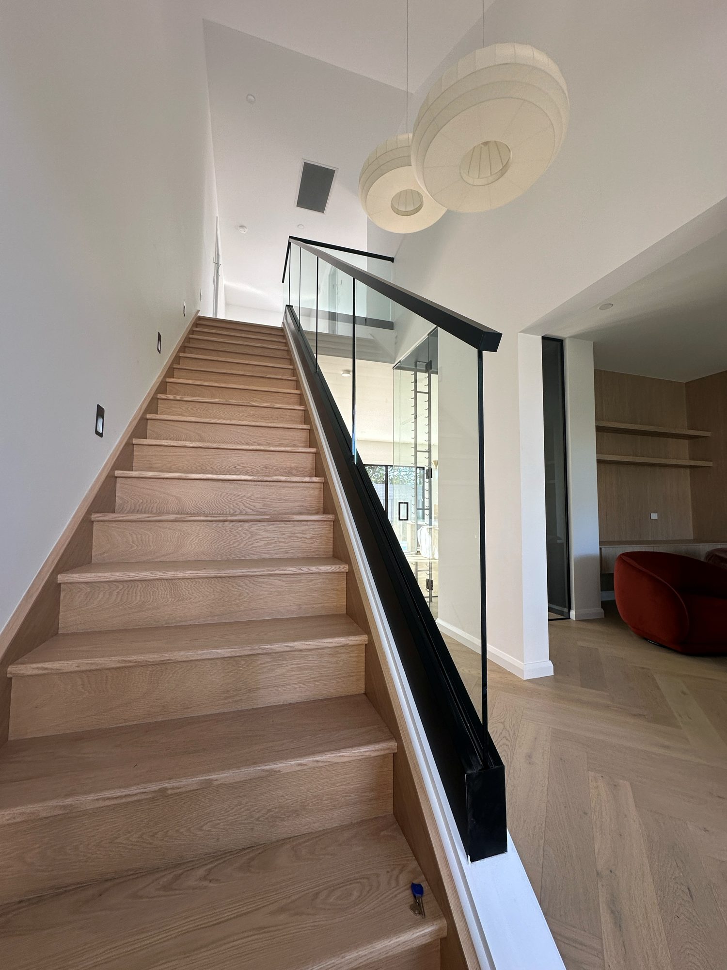 Frameless glass staircase balustrade with black handrail, Adelaide